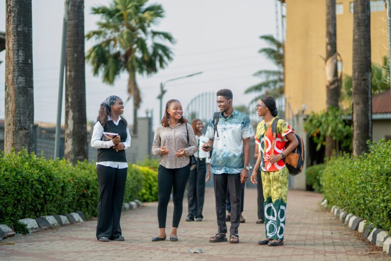 Shanahan University students talking together on the tree-lined campus walkway