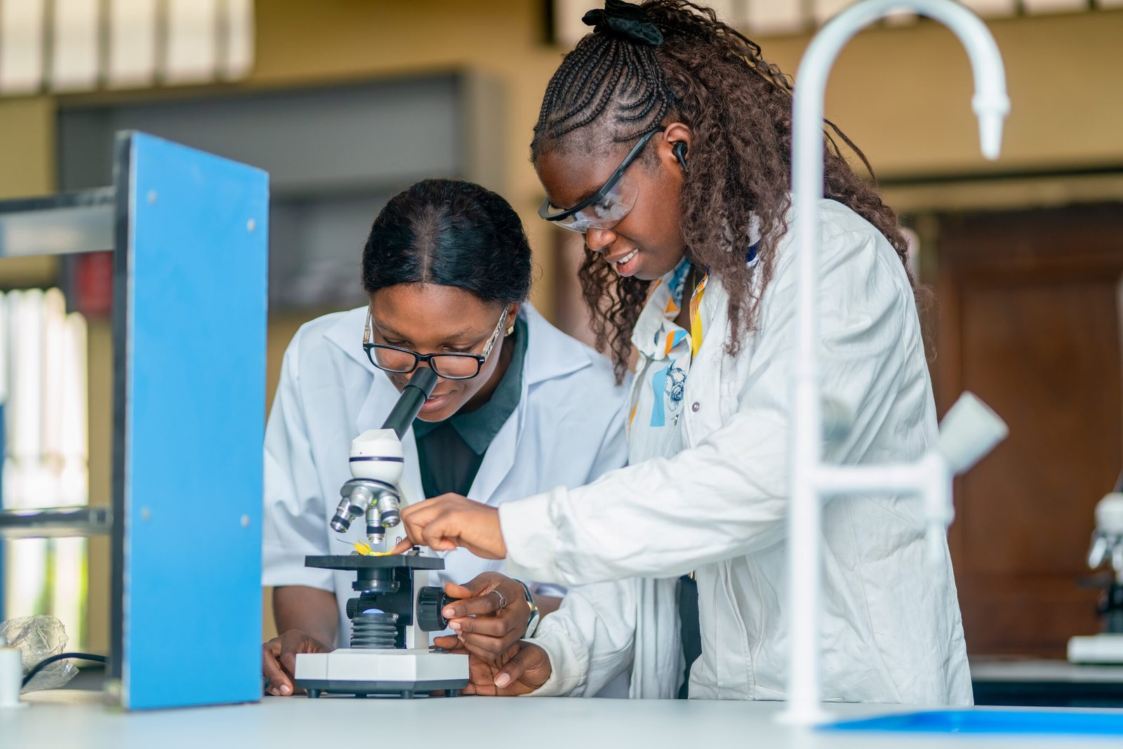 Two Shanahan University students working with a microscope in the laboratory