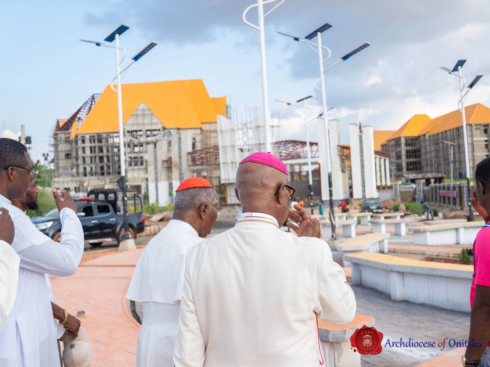 Clergy walking through the campus plaza with solar street lights during the site tour