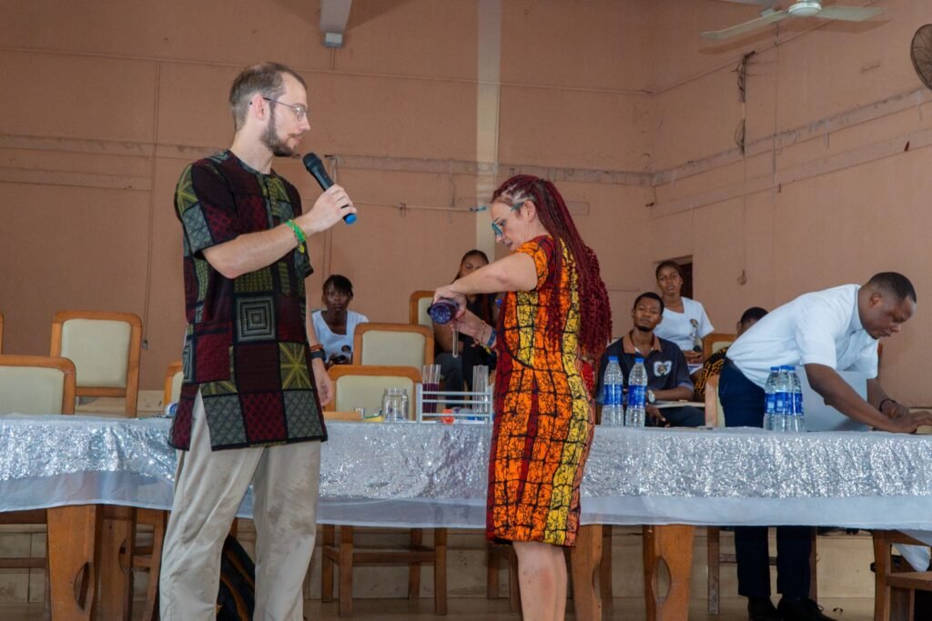 Dr. Réka Fodor pouring a natural pH indicator during the demonstration as Dr. Benedek looks on