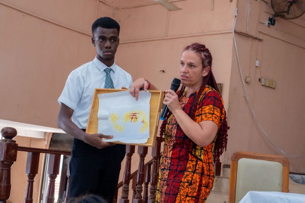 A student holds a tray showing the turmeric colour-change experiment result
